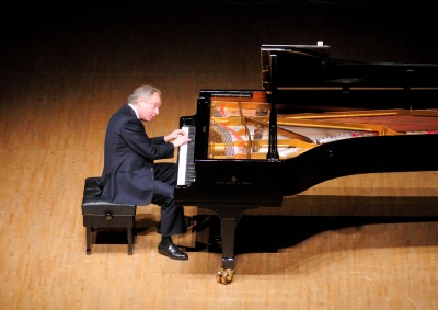 Andras Schiff playing the piano on stage
