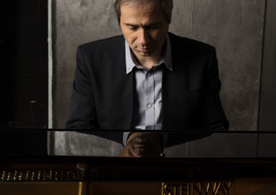 Piotr Anderszewski sitting at piano looking down