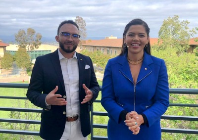 Hosts Zane Romano and Corina Giselle on a balcony overlooking campus