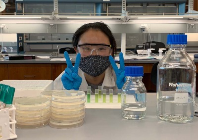 Woman flashing peace sign in bio lab