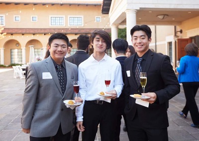 Soka students holding plate and wine glass during networking practice 