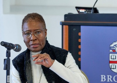 Professor Hortense J. Spillers gestures with her hand as she speaks into a microphone