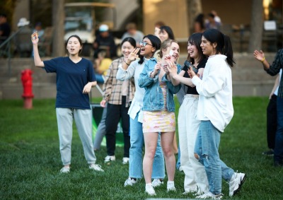 A group of students laugh together while enjoying the 21st Anniversary party