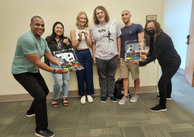 Jonathan Wray and Alisa Proctor present cupcakes to fourth-year students Mercedes Corrales, Kennah Watts, Skyler Wolf, and Leo Salvatore as congratulations for finishing their capstone projects.