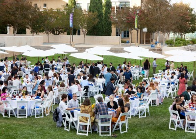 The Class of 2026 sit at circular white tables on the Campus Green during the Welcome Reception