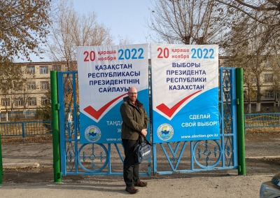 Dr. Shane Barter poses in front of an election sign in Kazakhstan.