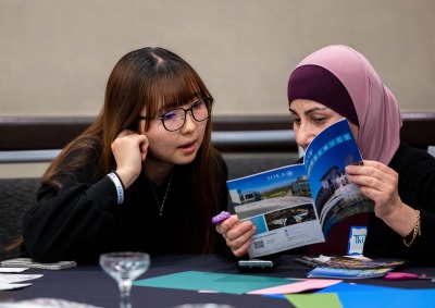 Two women look at a Soka brochure