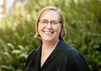 Headshot of Lisa MacLeod in front of greenery
