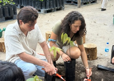 Two students dig with shovels during a native plant species workshop.