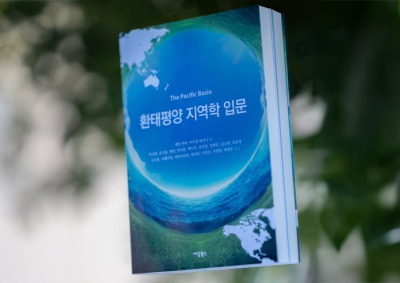 The textbook, “The Pacific Basin: An Introduction" is photographed in front of a white and green bokeh background.
