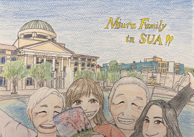 Colored pencil cartoon drawing of a family of four standing in front of Founders Hall and Peace Lake. They are smiling and holding up a children's book. "Miura Family in SUA!!" is stenciled in yellow writing in the top right of the drawing.