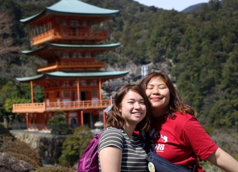 Two students in front of traditional Japanese architecture