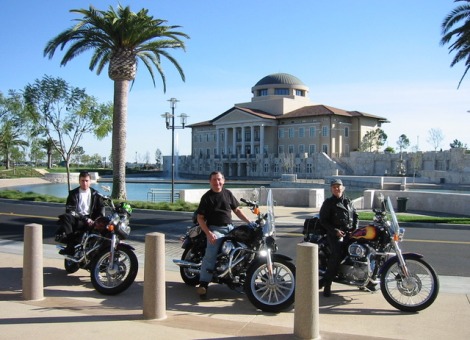 Three men sitting on motorcycles with Peace Lake in background