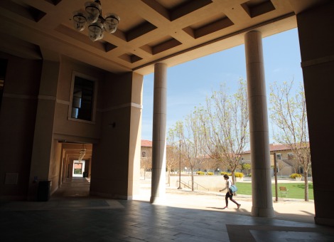 student walking under the exterior library columns