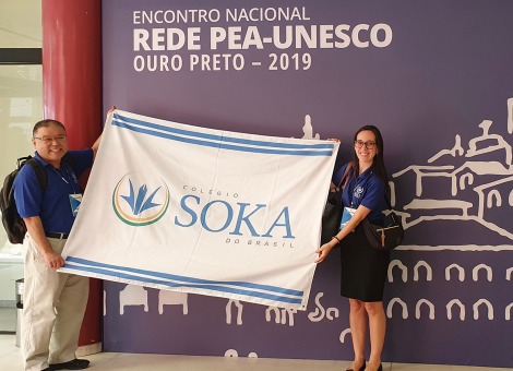 Two teachers holding Soka flag