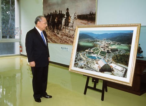 Daisaku Ikeda looks at large photo of the plans for the SUA Aliso Viejo campus