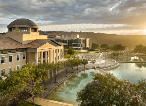 Aerial View of Founder's Hall and Peace Lake with the sun beaming on the horizon