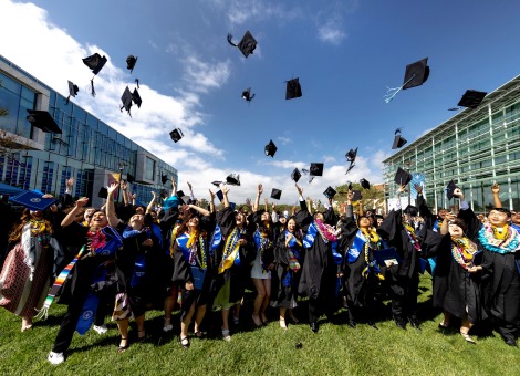 Image of students throwing graduation caps.