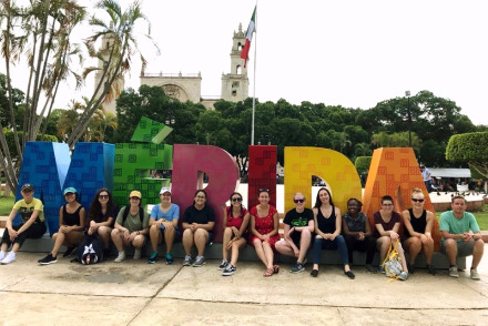 Students in front of letters spelling out Merida