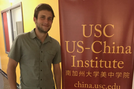 Student standing by a sign. 