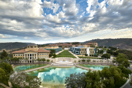 Exterior drone shot of Soka University of America's campus with blue sky and fluffy white clouds