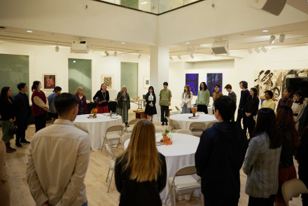 Members of the SUA community stand in a circle during the 2023 Thankstaking event held in Founders Gallery