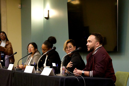 SUA alumni sit at a table with microphones to answer questions during a Career Night event
