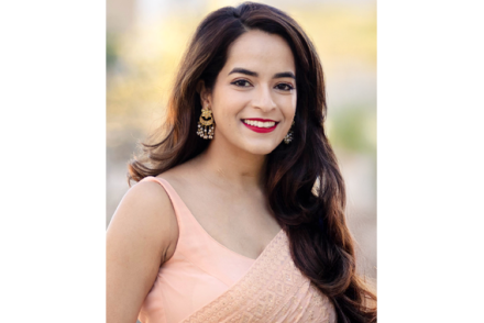 Nandini Puri wears a light pink dress and smiles for a photo