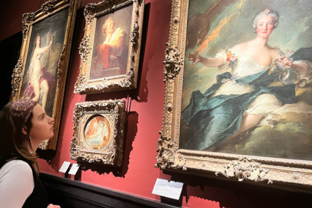 A girl looks at a painting in an art museum