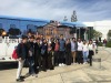 A group of students pose in front of the Soka University bus