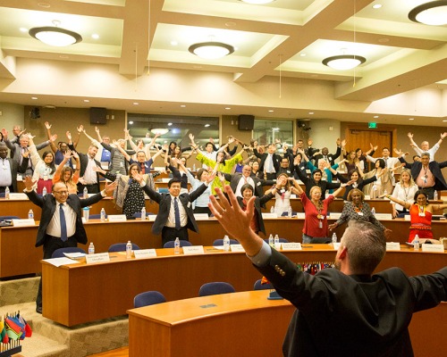 Educators raises their arms during a conference lecture