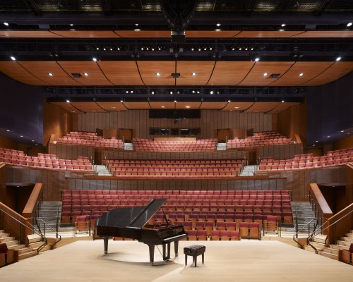 Interior of empty Concert Hall with piano in the center of the stage. 