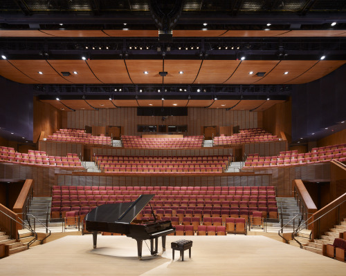 Interior of empty Concert Hall with piano in the center of the stage. 