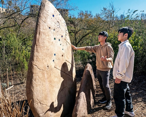 Students looking at a large boulder in the desert