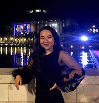 Student wearing black dress smiling at camera