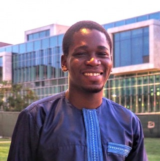 Student wearing blue shirt smiling at camera