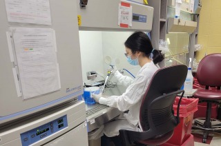 Reika Nyunoya sitting at desk in lab