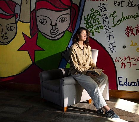 woman seated in front of artwork